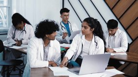Indian medical students working on computer in public library. Diverse young people studying on laptop in college library, discussing the health result of patient consulting. Intelligent future doctor - Powered by Shutterstock - Get 15% off with code: PIKWIZARD15