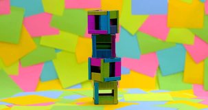 creativity to make staples in the form of a box on a rotating table with a background of multicolored paper sticky notes, 4K DCI