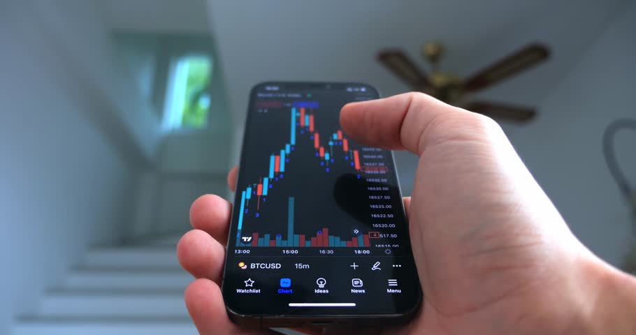 Crypto enthusiast using smartphone app analyzing financial data stock market price on smartphone checking online trading platform application, buying cryptocurrency investments on home office interior Royalty-Free Stock Footage #1102608315