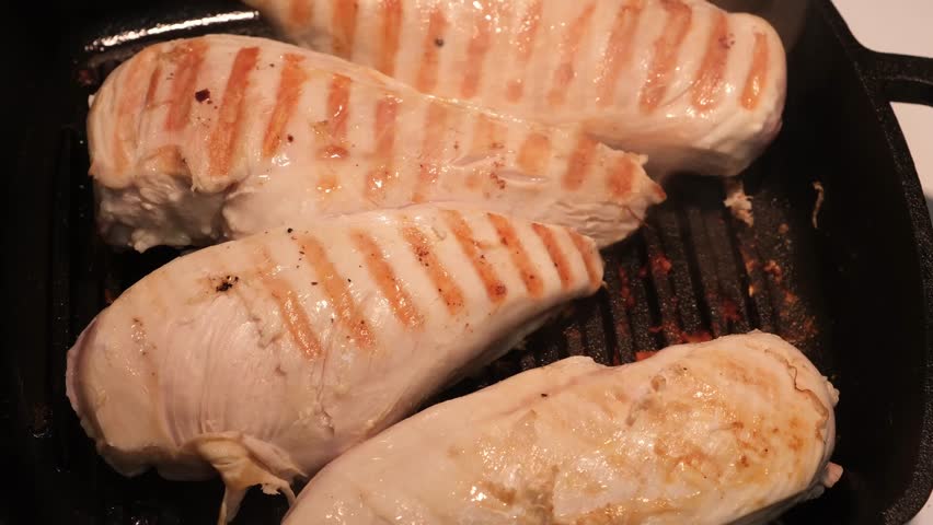 Closeup of hot chicken breasts smoking on hot pan. Turning with tongs. Grill marks Royalty-Free Stock Footage #1102609609
