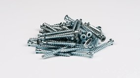 Screw-Confirmat for furniture, screw with hexagonal slot isolated on white background. Confirmat furniture 6.4x50. Loop motion. Rotation 360. Side view. 4K UHD video footage 3840X2160