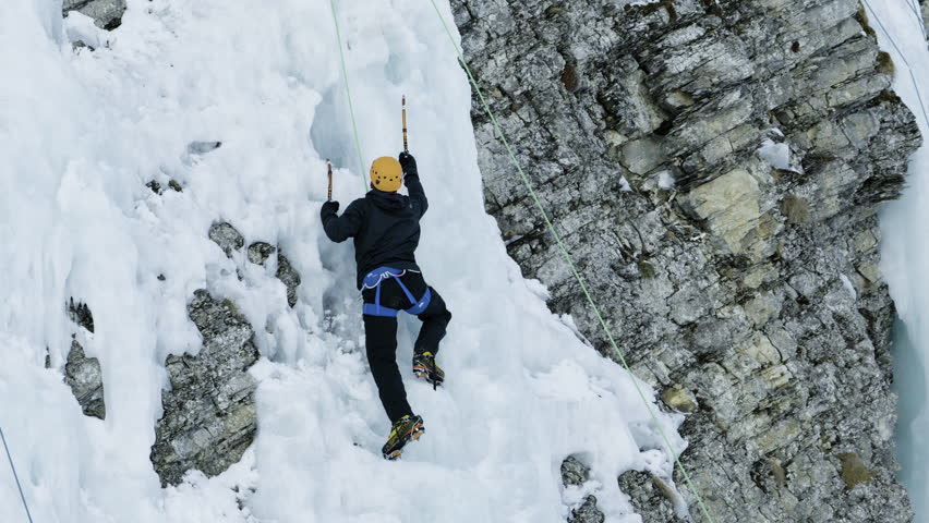 Ice climbing in famous Adelboden, Switzerland - climber ascending steep ice wall Royalty-Free Stock Footage #1102613785