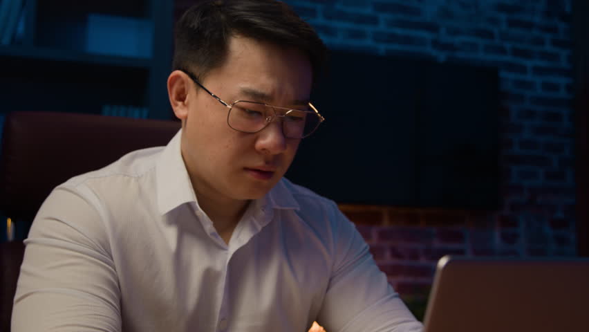 Stressed Asian businessman in glasses working with laptop at night in home office exhausted ill tired Korean middle-aged man overworked executive feel headache pain migraine stress business failure Royalty-Free Stock Footage #1102614147