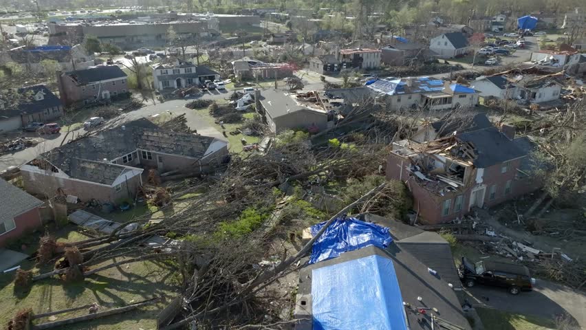 Damage in a neighborhood from March 31, 2023 tornado in Little Rock, Arkansas and drone video low moving forward.