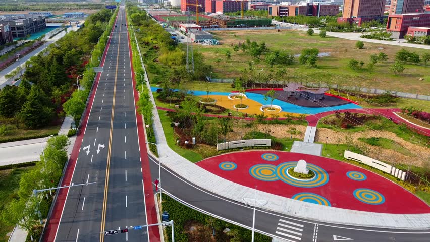 Aerial Nanhai New District China with high-rise and empty road, drone forward