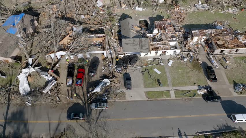 Damage in a neighborhood from March 31, 2023 tornado in Little Rock, Arkansas and drone video moving forward close up.