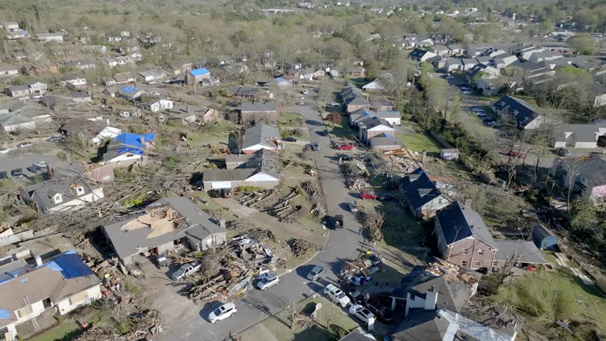 Damage in a neighborhood from March 31, 2023 tornado in Little Rock, Arkansas and drone video moving forward wide shot.