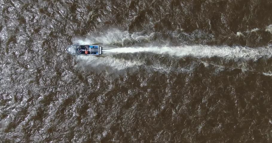 Top view of a high-speed boat with a motor with fishermen on a fast river. mountain river