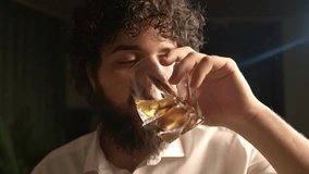 caucasian man drinks whiskey from a glass and says something on camera. curly man drinking whiskey. alcohol addiction.  - Powered by Shutterstock - Get 15% off with code: PIKWIZARD15