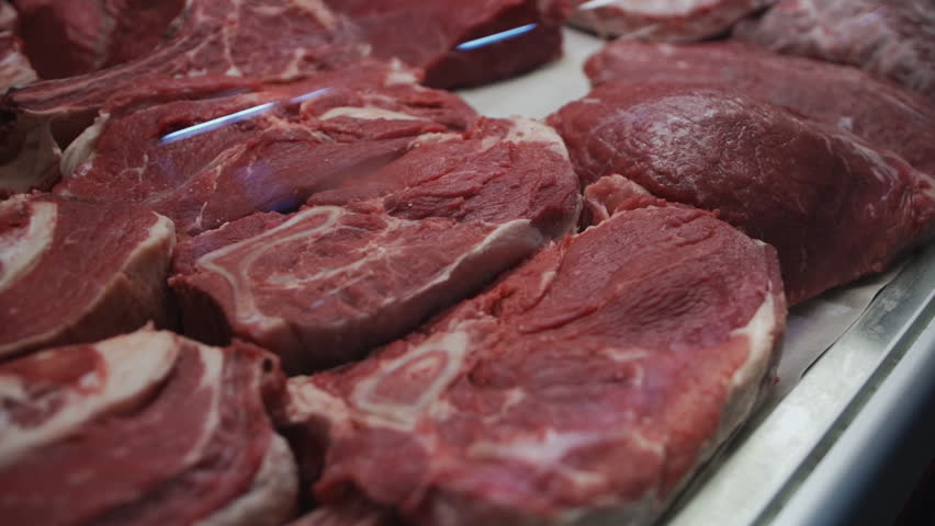 raw beef steaks lay on butcher's table at grocery market Royalty-Free Stock Footage #1102630435