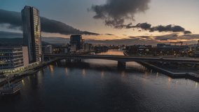 Establishing Aerial View Shot of Belfast UK, Northern Ireland, United Kingdom, dramatic sky, rise up, crane shot over river Lagan