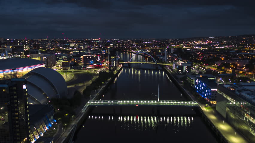 Establishing Aerial View Shot of Glasgow UK, Lanarkshire, Renfrewshire, Scotland United Kingdom, night evening blue hour, trak low in