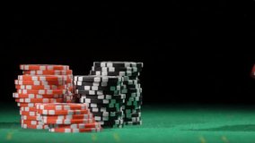 Game of dice. Gambling in the casino. Throws red dice, slow motion. Red and black chip stacks on a green gaming table. Betting. Fortune, risk and win. - Powered by Shutterstock - Get 15% off with code: PIKWIZARD15