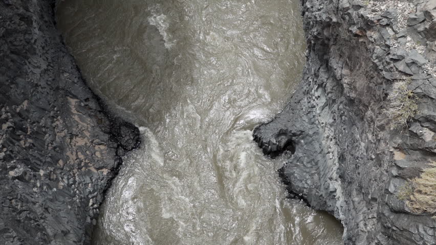 slow motion of white water rapids flowing through a narrow gorge, causing swirls along the legendary Ruta 40 in Argentina.