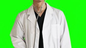 A doctor examining with a stethoscope. He wears navy blue scrubs and a white doctor's coat. upper body. Chromakey.