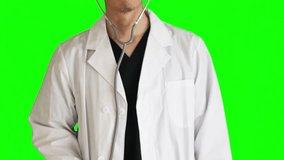 A doctor examining with a stethoscope. He wears navy blue scrubs and a white doctor's coat. upper body. Chromakey.