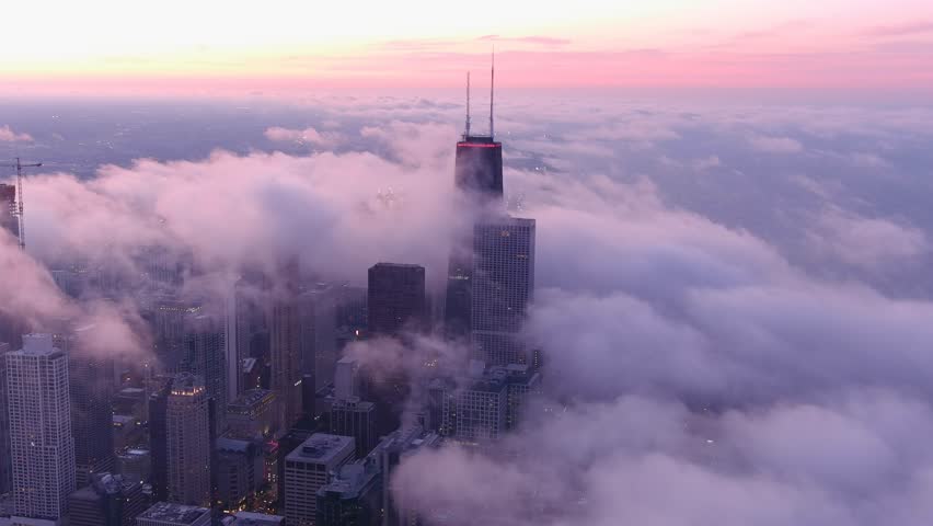 A chicago skyline consist of misty clouds. Foggy, white, beautiful, view of John Hancock tower and the city of Chicago. Sunset of chicago.