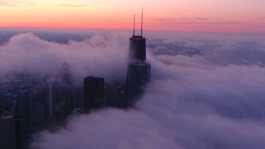 A chicago skyline consist of misty clouds. Foggy, white, beautiful, view of John Hancock tower and the city of Chicago. Sunset of chicago.