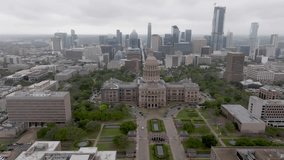 Texas state capital building with Austin, Texas skyline and drone video moving in a circle.