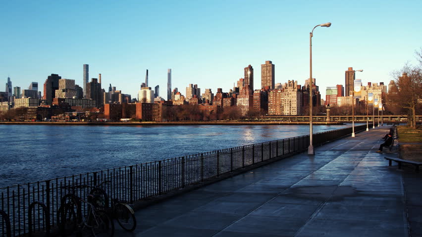 Aerial view low over the East river, approaching the cityscape of Yorkville, New York, USA