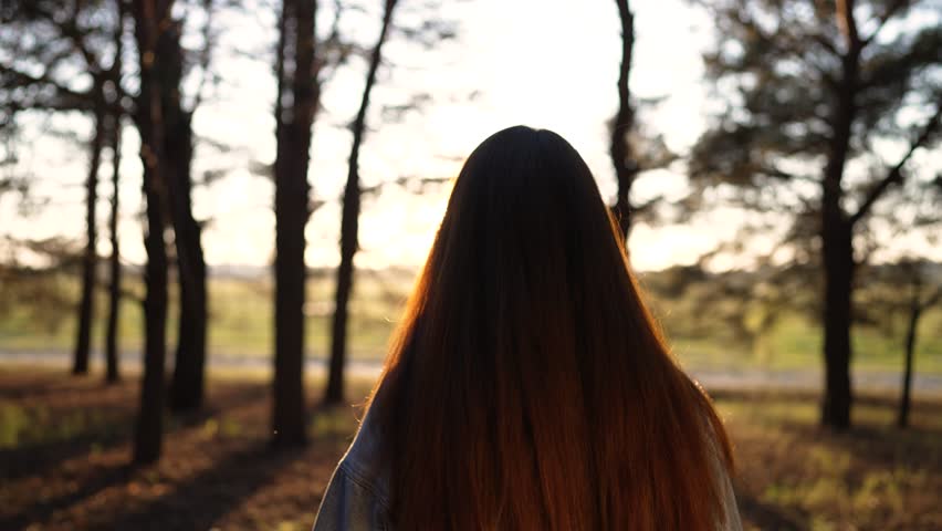 Autumn forest nature in the park. Woman girl travels. Active trekking freedom of travel. Hiking in the forest. Summer long walk. Woman girl distance walk. Girl with long hair in the sun in the forest.