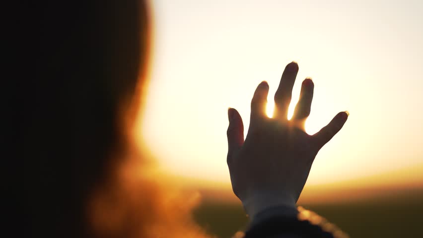 Hand of happy girl at sunset. Sunset between the hands of girl. Happy girl with long hair dreamily stretches out her hand to sun. Child's dream hand to the sun. happy family concept. Freedom in nature Royalty-Free Stock Footage #1102646139