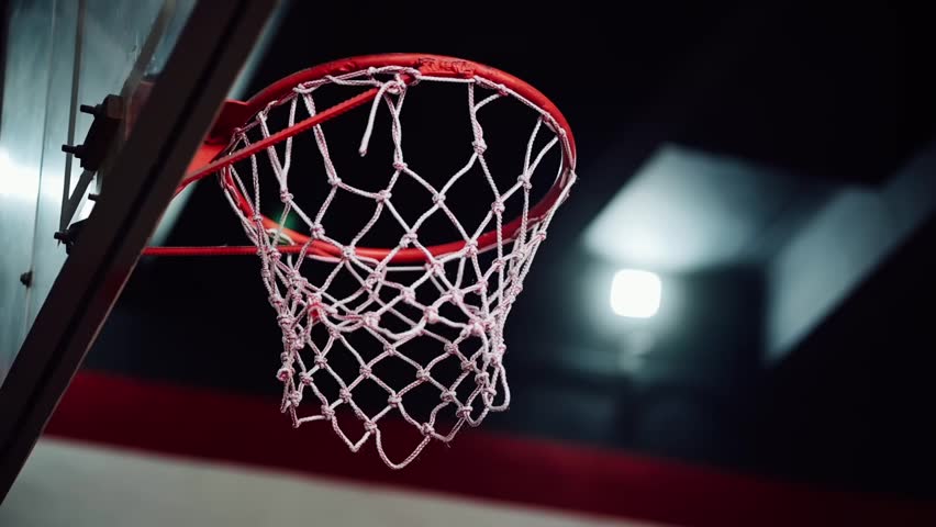 Basketball going into hoop after someone shoots the ball.