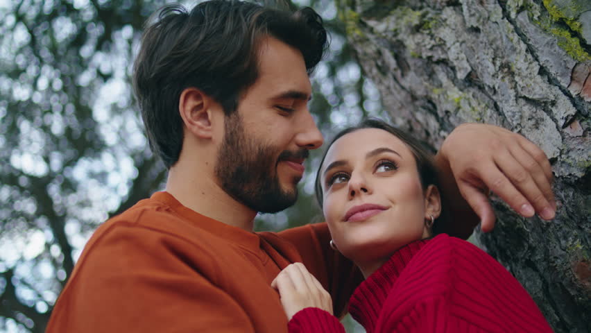 Romantic handsome man hugging happy woman leaning on wide forest tree close up. Loving young couple laughing enjoy weekend on autumn nature. Cheerful tender family pair relaxing feeling joy outdoors. Royalty-Free Stock Footage #1102648887