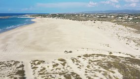 Aerial video on the coast of Israel in the area of Maagan Michael, with people riding horses. Israel
