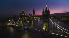 Establishing Aerial View Shot of London UK, United Kingdom, purple sunset over Tower Bridge