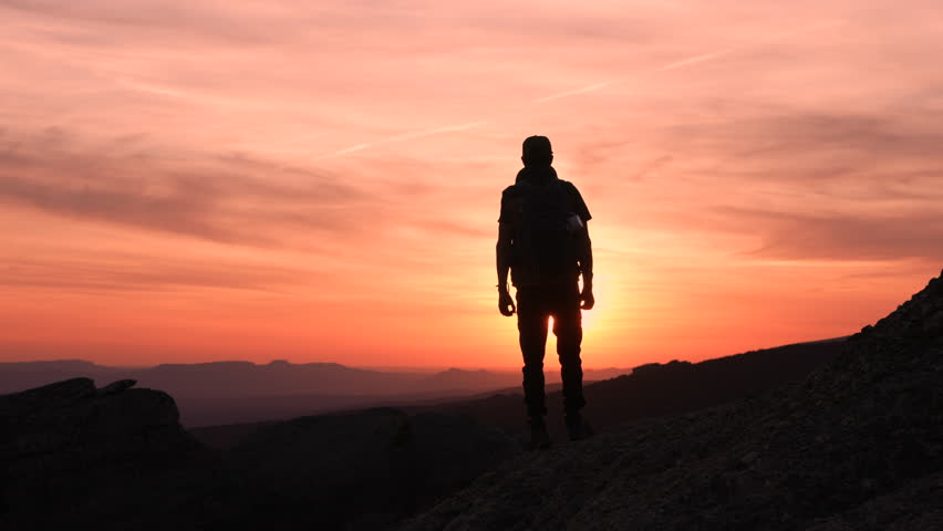 An adventurer reaching the top in a beautiful sunset on the mountain Royalty-Free Stock Footage #1102658717