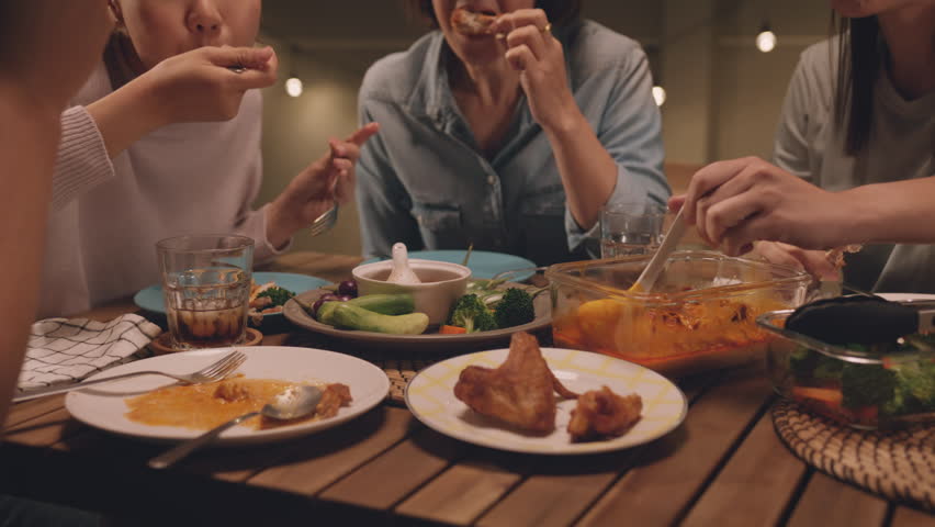 Enjoy eat yummy thai food with rice curry and drink at dine table outdoor house night party with mum. Asia older people mom and young adult child smile relax meet happy picnic meal warm time talk fun.