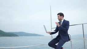 Businessman enjoy outdoor lifestyle remote online working corporate business on laptop computer during travel ocean on luxury private catamaran boat yacht sailing in the sea on summer holiday vacation