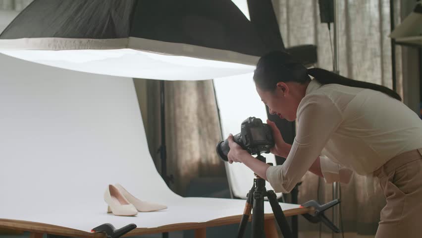 Asian Female Photographer Checking The Photos Of Women'S Shoes After Taking Them In Home Studio 
 Royalty-Free Stock Footage #1102667189