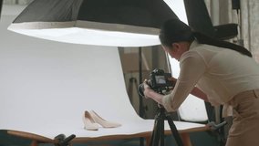 Asian Female Photographer Checking The Photos Of Women'S Shoes After Taking Them In Home Studio 
 - Powered by Shutterstock - Get 15% off with code: PIKWIZARD15