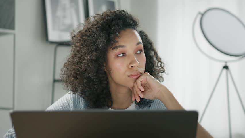 Sad African business woman finishing computer work and closing laptop, looking away with deep thoughts of undone project, seating at workplace feeling stressed dissatisfied by task not done in time 4K Royalty-Free Stock Footage #1102675425