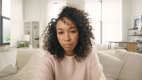 Young woman of color speaking on video call. Vlogger with afro hairstyle using smartphone talking at camera webcam online, selfie call, record lifestyle vlog, blogger communicating online streaming