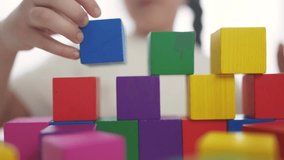 child girl in kindergarten play with blocks on table by the window. education development fun children game concept. child kid play with blocks at home rejoice having. child play cube at home - Powered by Shutterstock - Get 15% off with code: PIKWIZARD15