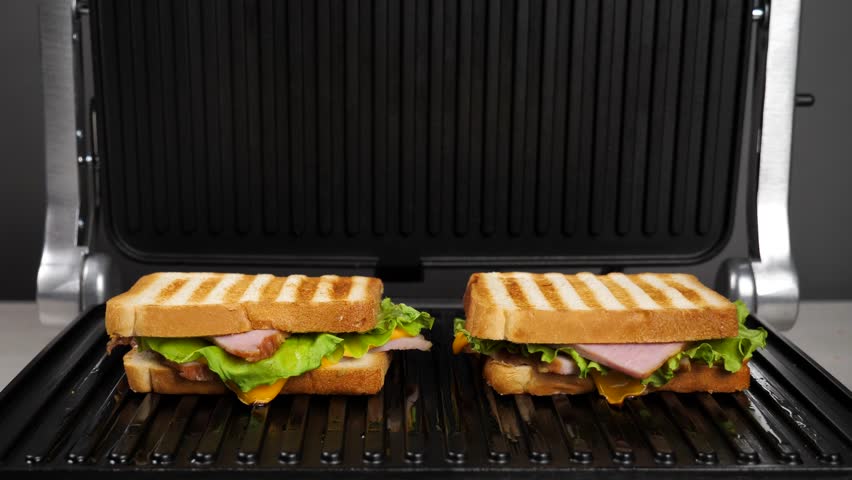 Cooking sandwiches on an electric grill. white bread toast