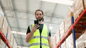 Warehouse worker using mobile smartphone and walking in storehouse. Male engineer happy smiling worker celebrating success at warehouse goods storage - Powered by Shutterstock - Get 15% off with code: PIKWIZARD15
