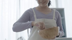 A woman making sweets while watching a video