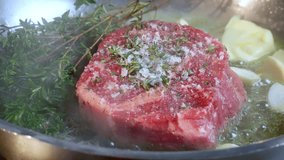 Cooking steak in cast iron pan in the kitchen at home. Slow motion video.