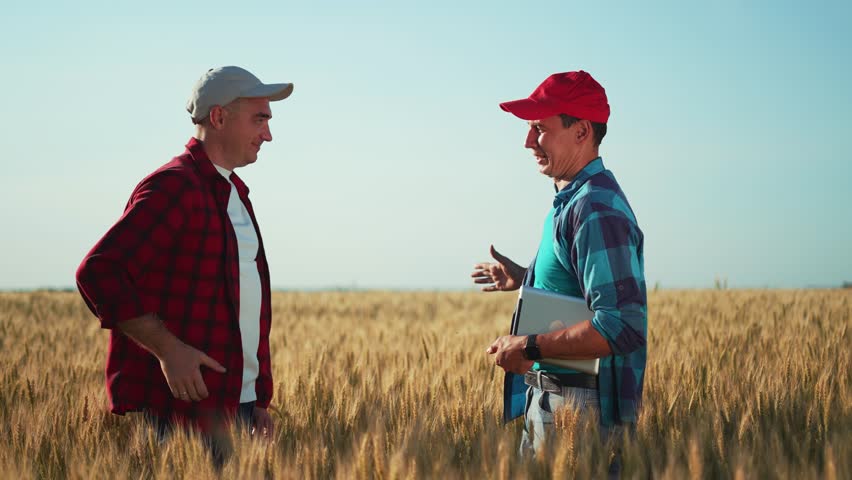 Teamwork in agriculture. Farmers shaking hands in a wheat field at sunset. Rural landscape in countryside. People shaking hands conclusion of a contract. Teamwork in business. Checking wheat harvest. Royalty-Free Stock Footage #1102684297