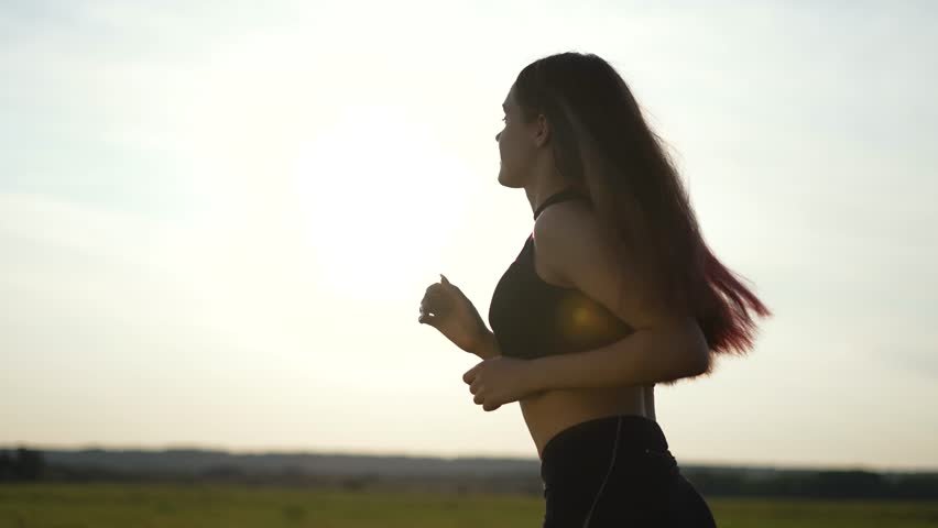Girl runs on summer morning in nature. Silhouette woman active lifestyle. Young healthy girl goes in for sports at sunset. Travel jogging outdoors. Active fitness girl running in the park silhouette Royalty-Free Stock Footage #1102684315