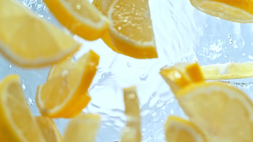 Super Slow Motion Shot of Fresh Lemon Slices Falling into Water Whirl at 1000 fps. Royalty-Free Stock Footage #1102688953