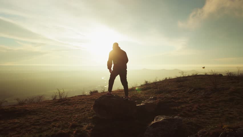 One Successful Happy Travel Man Standing Top Joy and Raises Hands Up. Joyful Silhouette Man Looking at View Sunset Sky Behind Mountains. Adventure Traveling Hike Man Hands Raised on Hill, slow motion Royalty-Free Stock Footage #1102693787