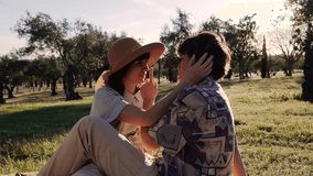 closeup slow motion of two girls couple lesbian homosexual lgbt sitting on a picnic in the park romantic hugging