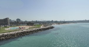 Aerial footage Tel Aviv beach promenade with the line of hotels in the background. Filmed in C4K Apple ProRes 422 HQ