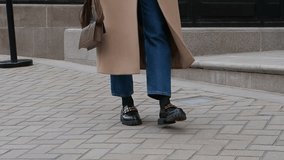 Woman walking street in fashionable spring or autumn clothes cashmere coat, jeans, black loafers shoes and handbag. Female model in motion, street style fashion, close up legs - Powered by Shutterstock - Get 15% off with code: PIKWIZARD15