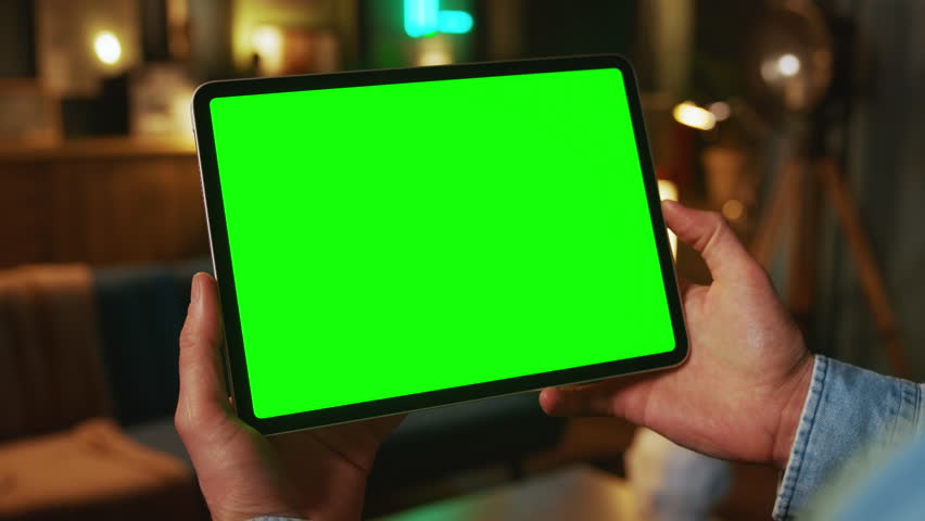 Close up hands holding on tablet computer with horizontal green screen. Mock up. In the evening. Work - Powered by Shutterstock - Get 15% off with code: PIKWIZARD15